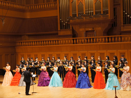 パイプオルガンのあるホールの舞台に立ち、合唱する音楽教育講座の学生たち